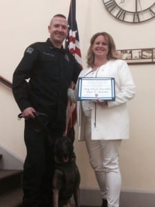 Officer Justin Ellenton & K9 Stryka pose with Karen Lounsbury, who generously donated the funds to secure a protective tactical vest in loving memory of her son, PFC Bryan Lounsbury.